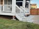 Backyard view featuring a well-maintained lawn, a gray patio, and stairs leading to a covered porch at 2089 S Fultondale Way, Aurora, CO 80018