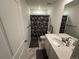 Neutral bathroom features a single sink vanity, framed mirror, and a shower/tub with floral shower curtain at 2089 S Fultondale Way, Aurora, CO 80018