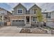 Charming two-story home showcasing stone accents, neutral paint, a two-car garage, and a covered front porch at 2089 S Fultondale Way, Aurora, CO 80018