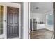 Entryway view into a kitchenette featuring a stainless refrigerator, and white cabinets at 2089 S Fultondale Way, Aurora, CO 80018