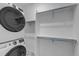 Convenient laundry room with stackable washer and dryer and built in closet shelving at 2089 S Fultondale Way, Aurora, CO 80018