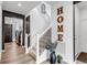 Elegant staircase with carpeted treads, black iron railings, and a decorative 'HOME' display at 2089 S Fultondale Way, Aurora, CO 80018