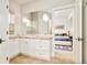 Bathroom showcasing a sink, tan tiled floor, and view to a bedroom via an open doorway at 5425 S University Blvd, Greenwood Village, CO 80121