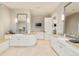 Bright bathroom featuring dual sinks with white cabinetry, sconces, and mirrors, complemented by a neutral color palette at 5425 S University Blvd, Greenwood Village, CO 80121
