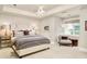 Bright bedroom featuring stylish antler chandelier, neutral palette, and comfortable seating area near the window at 5425 S University Blvd, Greenwood Village, CO 80121