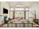 Bright living room featuring large windows, stylish furnishings, a fireplace, and views of the outdoor landscape at 5425 S University Blvd, Greenwood Village, CO 80121