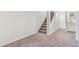 Basement features neutral paint, neutral carpet, staircase with white banister at 18751 E Mexico Ave, Aurora, CO 80017