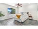 Bright bedroom with large window and contemporary decor featuring hardwood style floors at 18751 E Mexico Ave, Aurora, CO 80017