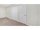 Bedroom featuring neutral carpet and closet with bi-fold doors at 18751 E Mexico Ave, Aurora, CO 80017