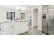Contemporary kitchen with white cabinets, stainless steel refrigerator, and view to dining area at 18751 E Mexico Ave, Aurora, CO 80017