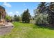 Spacious backyard featuring lush green grass, mature trees, and a cozy patio area perfect for outdoor relaxation at 11037 Cambridge Pl, Parker, CO 80138