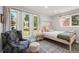 Bright bedroom with large windows, comfortable bed, and a stylish accent chair for relaxation at 11037 Cambridge Pl, Parker, CO 80138