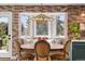 Close up of dining table with exposed brick accent wall and cozy window seating area at 11037 Cambridge Pl, Parker, CO 80138