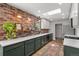 Contemporary kitchen with exposed brick wall, white countertops, and green cabinets at 11037 Cambridge Pl, Parker, CO 80138