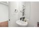 Half bathroom with a modern pedestal sink, framed mirror, and neutral decor at 10226 Worchester St, Commerce City, CO 80022