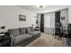 Living room featuring couch, desk, and window with dark curtains at 10226 Worchester St, Commerce City, CO 80022