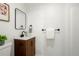 Stylish bathroom with wood grain cabinet, sleek black hardware, and modern mirror at 10703 Jordan Ct, Parker, CO 80134