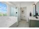 Bright bathroom featuring a soaking tub, glass shower, and modern vanity with stylish fixtures at 10703 Jordan Ct, Parker, CO 80134