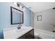 Bathroom featuring blue walls, a bathtub, a mirror, and white tile at 6327 Fenton St, Arvada, CO 80003