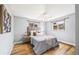 This bedroom is naturally lit with two windows, a ceiling fan, and hardwood floors at 6327 Fenton St, Arvada, CO 80003