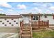 Inviting home with a wooden porch, attached garage, and a neatly manicured front lawn at 6327 Fenton St, Arvada, CO 80003