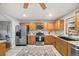This kitchen boasts stainless steel appliances, brown cabinets, and a large sink at 6327 Fenton St, Arvada, CO 80003
