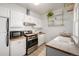 Bright kitchen featuring white cabinets, stainless steel appliances, and a stylish tile backsplash at 2023 E 20Th Ave, Denver, CO 80205