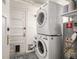 Well-organized laundry area with stacked washer/dryer unit, shelving, and a convenient door at 2023 E 20Th Ave, Denver, CO 80205