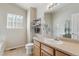 Bright bathroom featuring a single sink vanity, large mirror, and shelving for towel storage at 10517 Madison St, Thornton, CO 80233