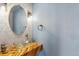 Modern powder room featuring round mirror, unique vessel sink, and wood shelf at 10517 Madison St, Thornton, CO 80233