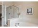 Bright bathroom featuring a glass shower, soaking tub, and white tile at 10517 Madison St, Thornton, CO 80233