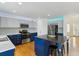 Modern kitchen with stainless steel appliances, island with barstool, and hardwood floors at 10517 Madison St, Thornton, CO 80233