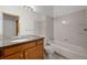 Clean bathroom offers neutral paint, tiled shower over tub, and wood vanity at 14447 Inca Ct, Westminster, CO 80023