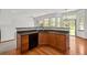 Corner kitchen island featuring a dark countertop, wood cabinets and a stainless steel sink at 14447 Inca Ct, Westminster, CO 80023