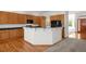 Eat-in kitchen featuring wood cabinets, a breakfast bar, and views to the front yard at 14447 Inca Ct, Westminster, CO 80023