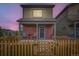 Attractive two-story home with a charming fenced front yard at dusk at 1199 Hummingbird Cir, Longmont, CO 80501