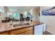 Open-concept kitchen with stone counters, dishwasher, and breakfast bar at 1199 Hummingbird Cir, Longmont, CO 80501