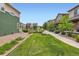 Landscaped front yard with a sidewalk, grass, rock beds, and various trees and shrubs at 1199 Hummingbird Cir, Longmont, CO 80501