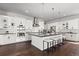 Bright kitchen with white cabinets, black countertops, stainless steel appliances, and island with seating at 2230 Rim Ridge Dr, Castle Pines, CO 80108