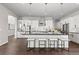 A kitchen features a large island with seating, stainless steel appliances and pendant lighting at 2230 Rim Ridge Dr, Castle Pines, CO 80108