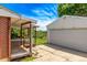 A wooden patio connects the house to the detached garage on a sunny lot with green grass at 3182 W Radcliff Dr, Englewood, CO 80110