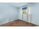 Bedroom featuring light blue walls and hardwood floors, lit by a window with white curtains at 3182 W Radcliff Dr, Englewood, CO 80110