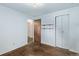 An interior bedroom with hardwood floors, a closet, built-in shelves, and a view into another room at 3182 W Radcliff Dr, Englewood, CO 80110