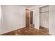 An interior bedroom with hardwood floors, a closet, a wardrobe, and a view into another room at 3182 W Radcliff Dr, Englewood, CO 80110