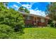 Red brick home with a lush green lawn and charming front porch, offering classic curb appeal at 3182 W Radcliff Dr, Englewood, CO 80110
