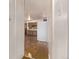 Hallway leading into a kitchen with dark cabinets and hardwood floors, with a white refrigerator at 3182 W Radcliff Dr, Englewood, CO 80110