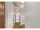 Hallway leading into a bathroom with white tiling, a bathtub, and a shower, with patterned carpet at 3182 W Radcliff Dr, Englewood, CO 80110