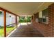 Spacious covered patio with wooden flooring and brick siding, perfect for outdoor enjoyment at 3182 W Radcliff Dr, Englewood, CO 80110