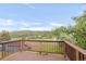 This deck has wood railings with a view of mountains, a field and a road at 3260 Bit Rd, Evergreen, CO 80439