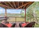 An outdoor deck has two chairs with a beautiful view of a valley and mountains at 3260 Bit Rd, Evergreen, CO 80439